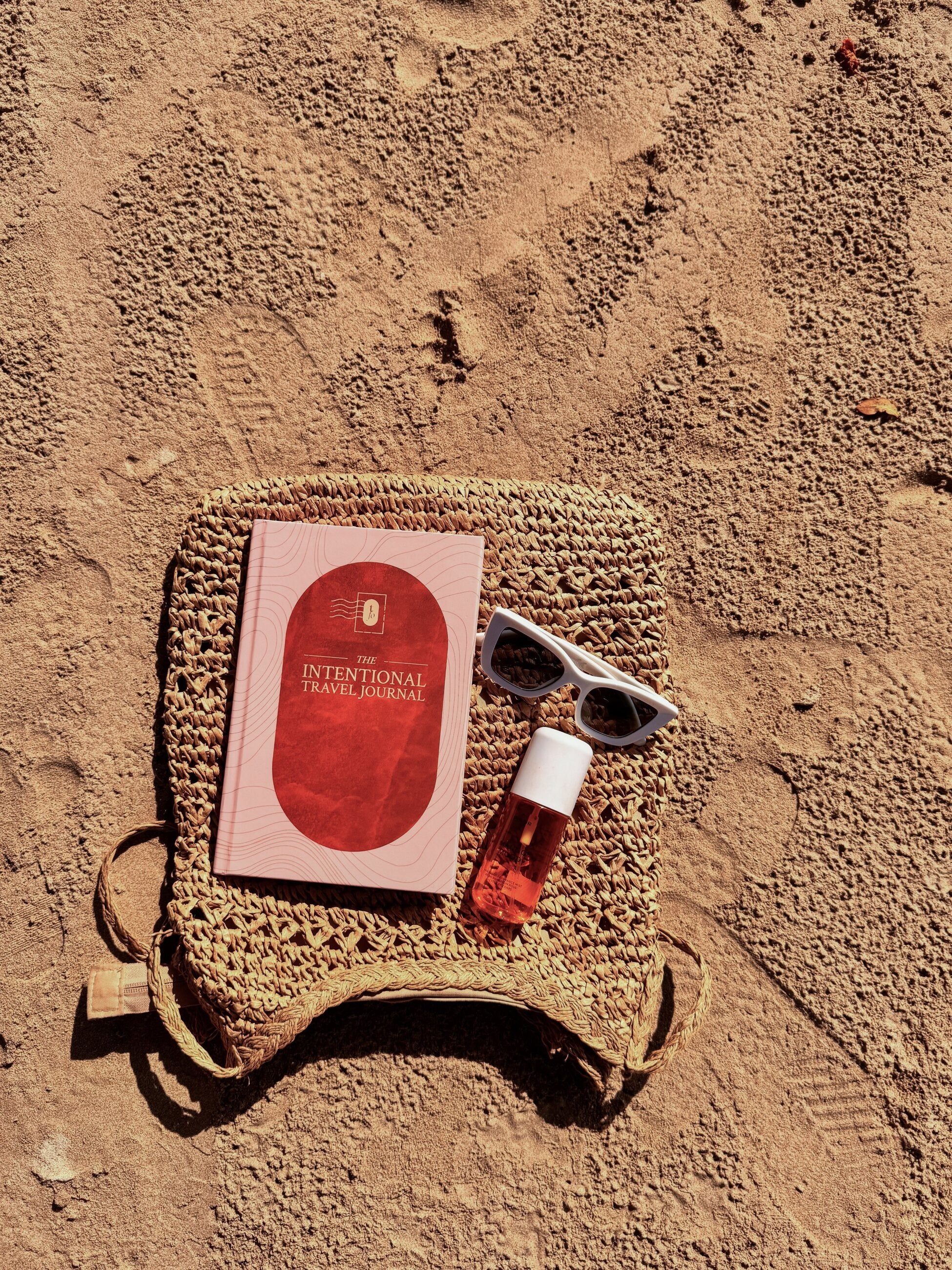 The Intentional Travel Journal resting on a woven travel bag